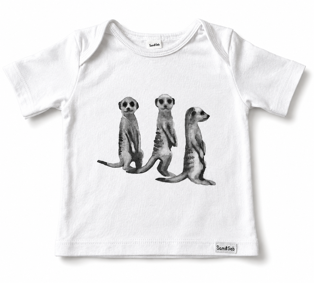 A white short-sleeve baby t-shirt featuring a black and white graphic print of three standing meerkats on the front. The brand name 'Sam & Seb' is visible on a small tag near the bottom right hem.