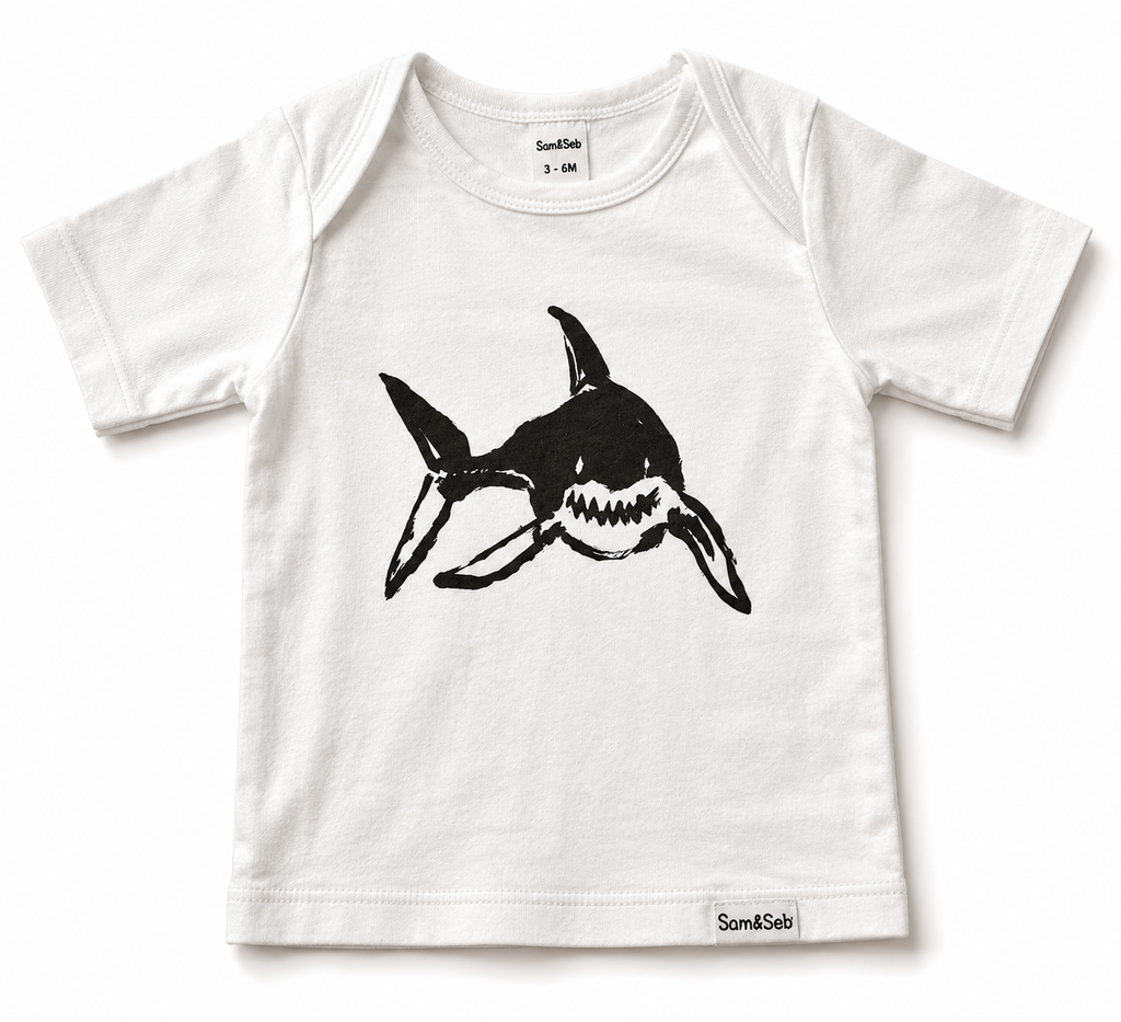 A white short-sleeve baby t-shirt with a black shark graphic printed on the front, featuring the brand name 'Sam & Seb' on the inner neck label and bottom hem.